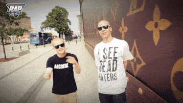 a man wearing a shirt that says " i see dead haters " stands next to another man