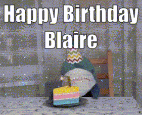 a stuffed shark is holding a piece of birthday cake with a candle in it