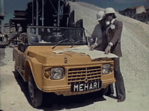 two men are looking at a map in front of a mehari