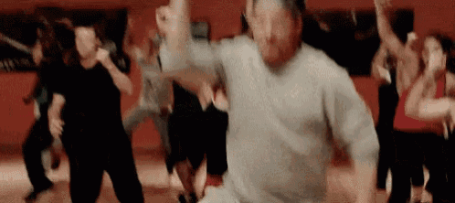 a man is dancing in front of a group of people .