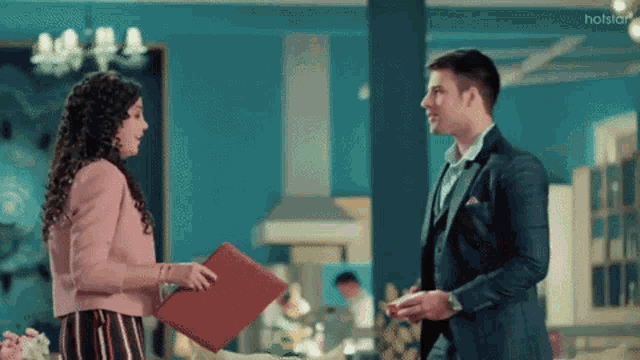 a man and a woman are standing next to each other in a room .