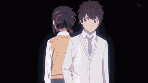 a man and a woman are standing next to each other in a dark room .