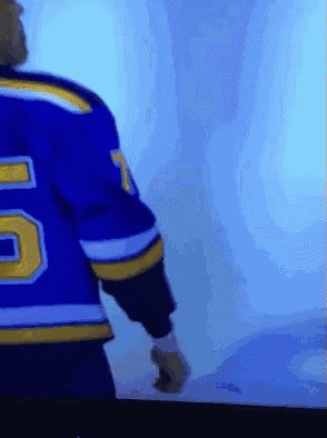 a hockey player wearing a blue jersey with the number 5 on it