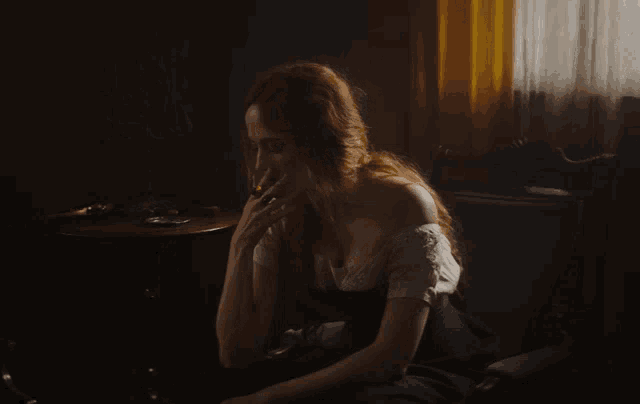 a woman with long red hair is sitting on a couch