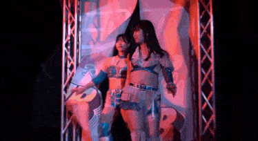 two women are standing next to each other in a tunnel .