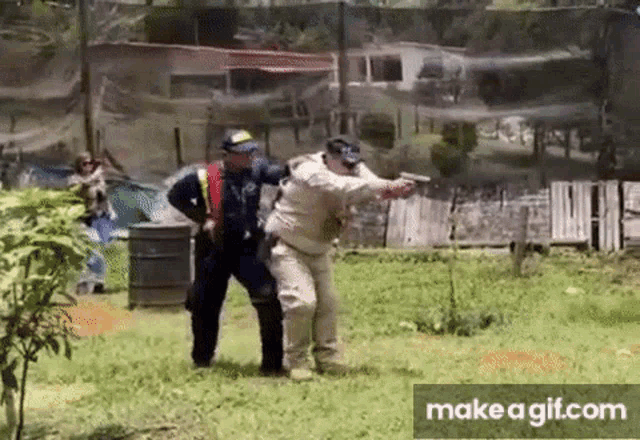 two men are playing a game of paintball and one of them is pointing a gun