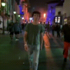 a blurry photo of a man walking down a street at night