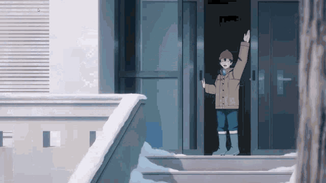 a boy in a brown jacket and red hat is standing in front of a door waving