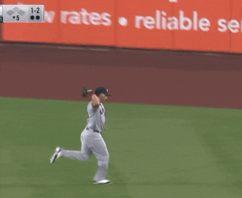 a new york yankees baseball player is running towards a base