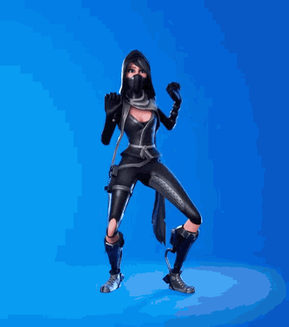 a woman in a black ninja costume is dancing with her arms in the air