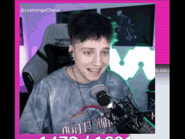 a young man wearing a shirt that says pink floyd is sitting in front of a microphone