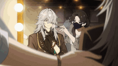 a woman wearing a mask is applying makeup to a man with long hair