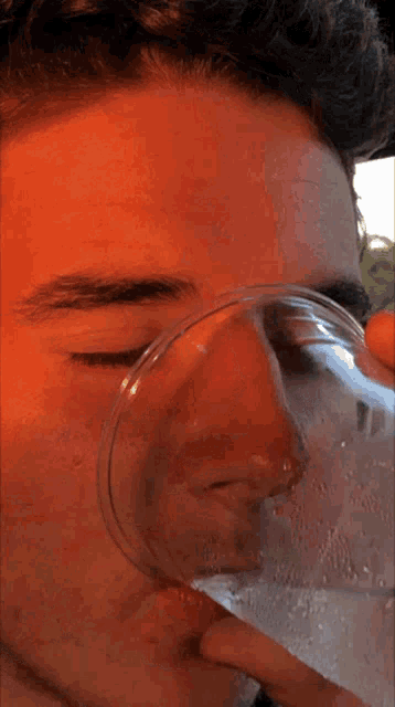a close up of a young man 's face with a red background