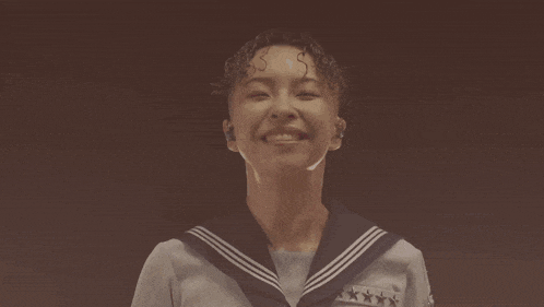 a woman in a sailor uniform with stars on the sleeves looks down