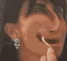 a woman wearing a necklace and earrings is looking at herself in the mirror .