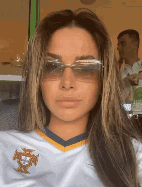 a woman wearing sunglasses and a white shirt that says portugal