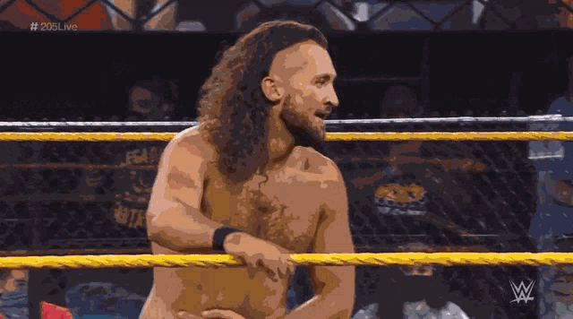 a shirtless wrestler in a ring with the hashtag # 205live