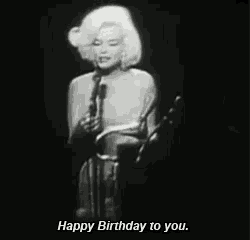a woman singing into a microphone with the words happy birthday to you
