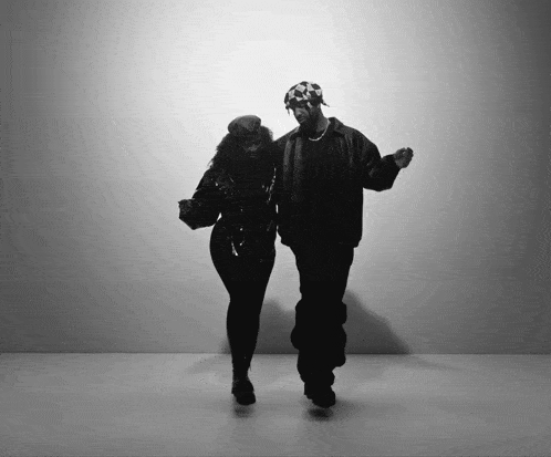 a man and a woman are dancing in front of a white wall