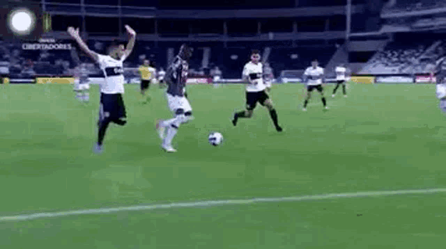 a group of men are playing soccer on a field .