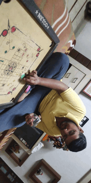 a man playing a game with a netco board behind him