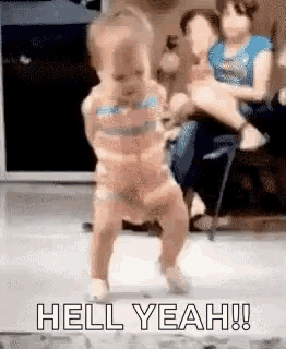 a little girl is dancing on the floor while a woman holds her in a chair .