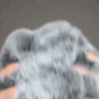 a blurred image of a person 's face with a gray background