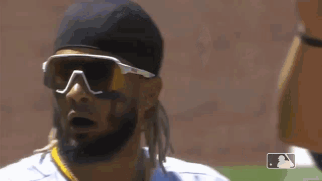a padres baseball player wearing sunglasses and a hat on the field .