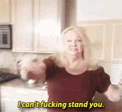 a woman in a kitchen says " i can t fucking stand you "