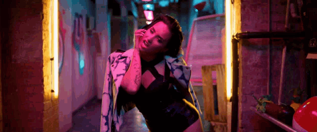 a woman is standing in a dark alleyway in a neon lighted room .