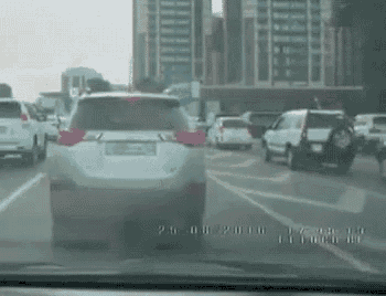 a car is driving down a city street in a busy traffic jam .