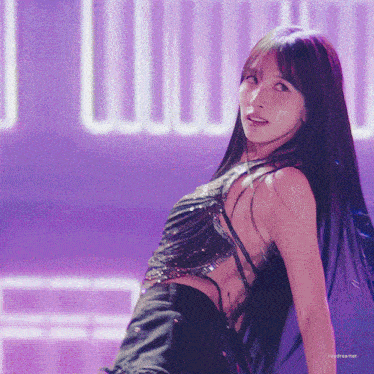 a woman in a black top is dancing in front of a purple background that says daydreamer on it