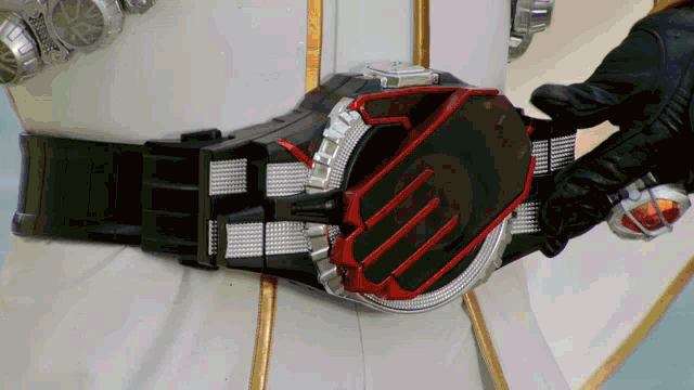 a person is wearing a belt that has a red and black buckle