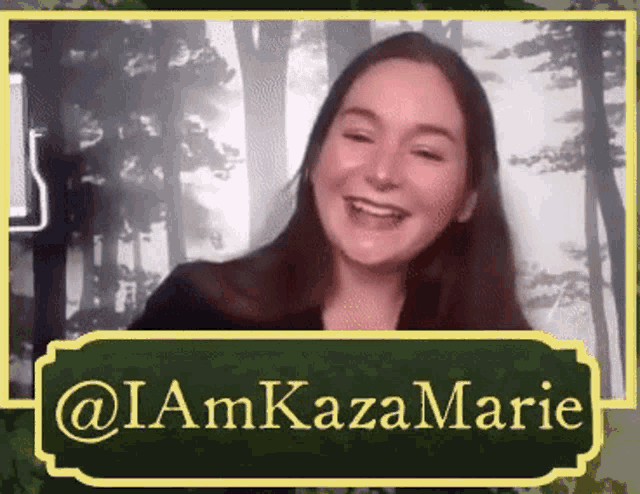 a woman is smiling in front of a green sign that says i am kazamarie