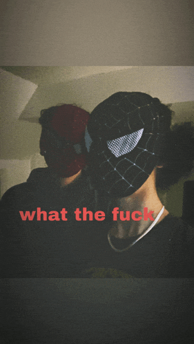 a man wearing a spider man mask stands next to another man wearing a spider man mask