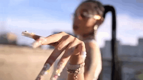 a close up of a woman 's hand with long nails and a ponytail .