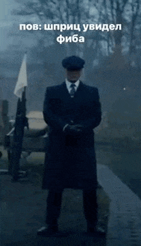 a man in a suit and hat is standing in the rain with a gun .