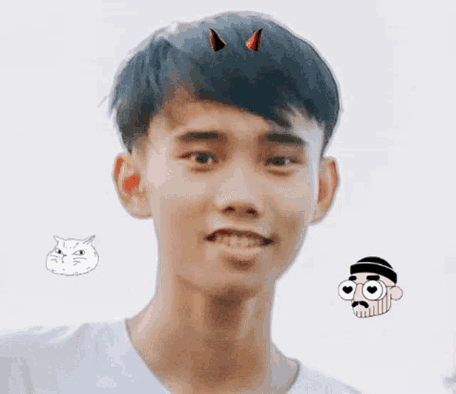 a young man with devil horns on his head is smiling