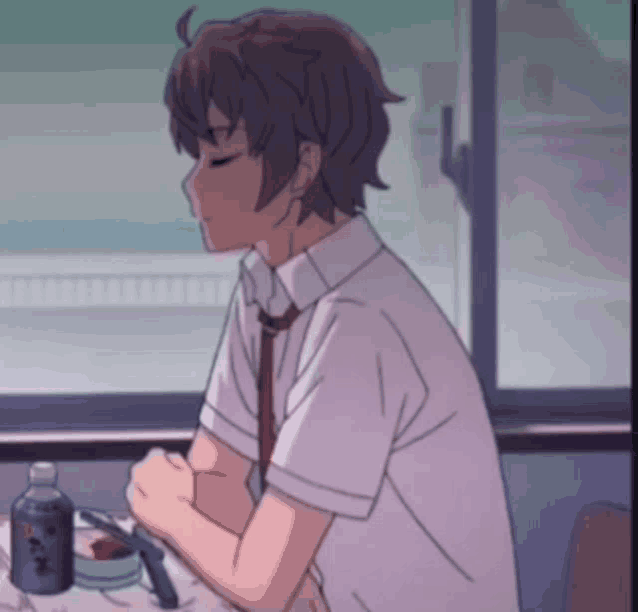 a boy in a white shirt and tie is sitting at a table with a can of beer on it