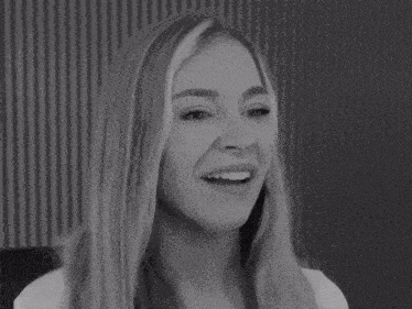 a black and white photo of a smiling woman