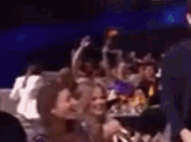 a blurry picture of a crowd of people sitting in a dark room