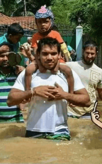 a man is carrying a child on his shoulders in the water