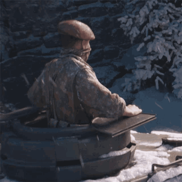 a man in a military uniform is sitting in a bucket in the snow