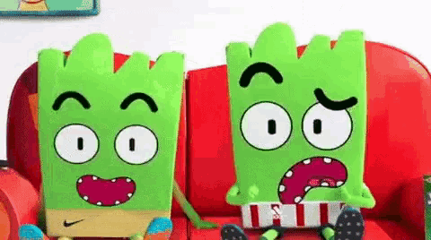 two cartoon characters are sitting on a red couch .