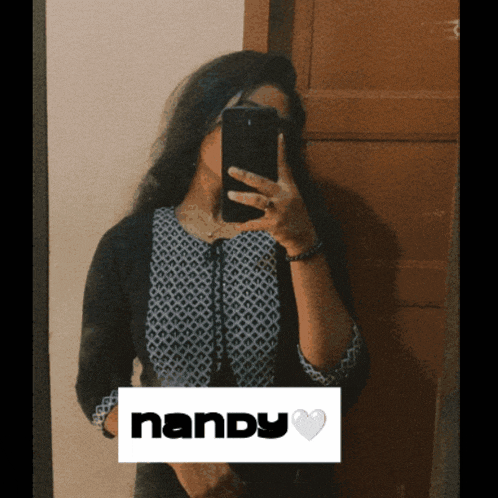 a woman is taking a picture of herself in a mirror with the name nandy visible