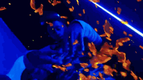 a person is dancing in a dark room with blue lights .
