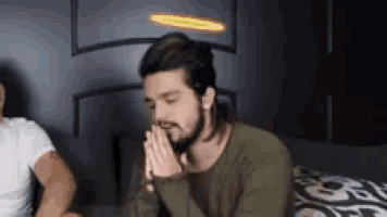 a man with a halo on his head prays with his hands folded