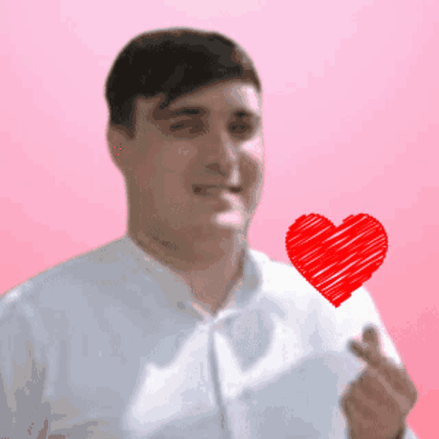a man is holding a red heart in his hand