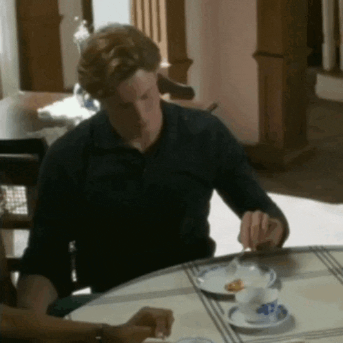 a man is sitting at a table with a plate of food on it