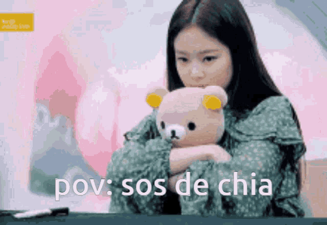 a woman is holding a teddy bear with the words pov sos de chia in the background .